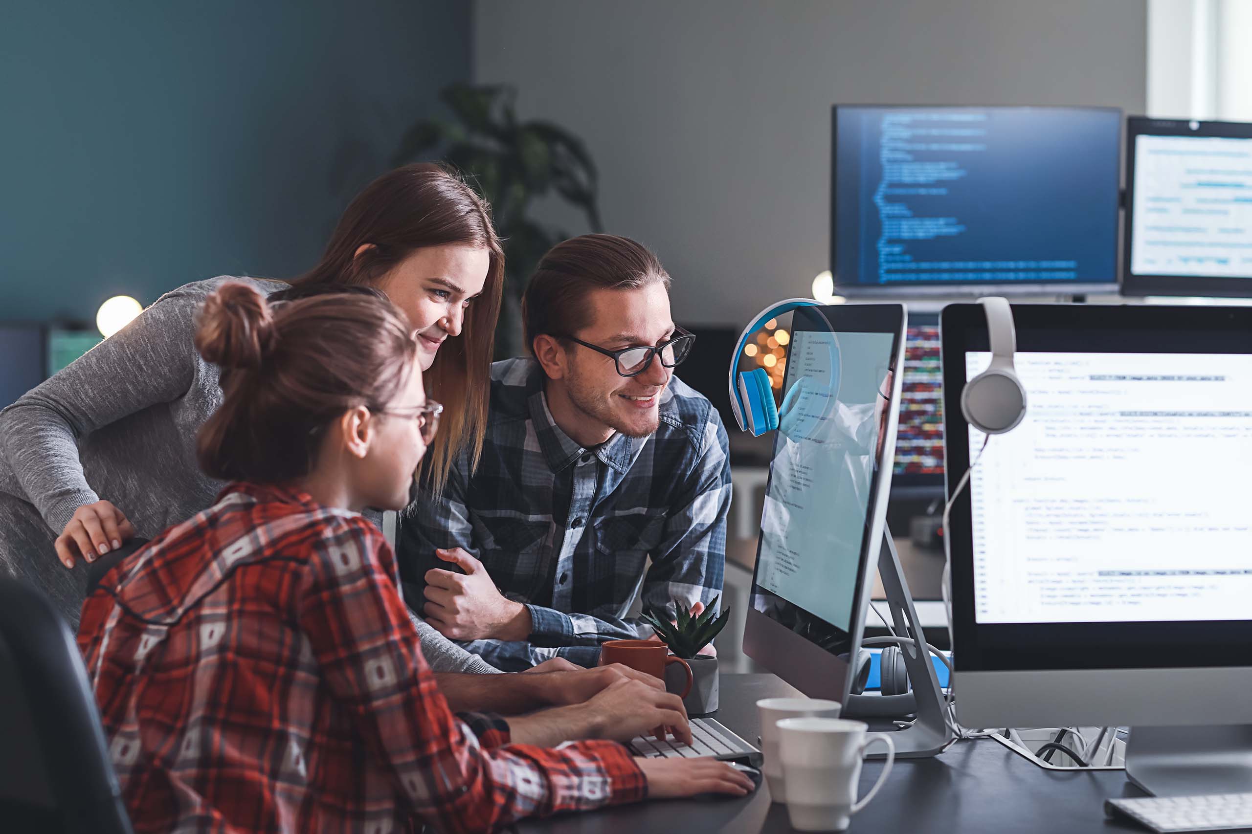 Three people working together at computer