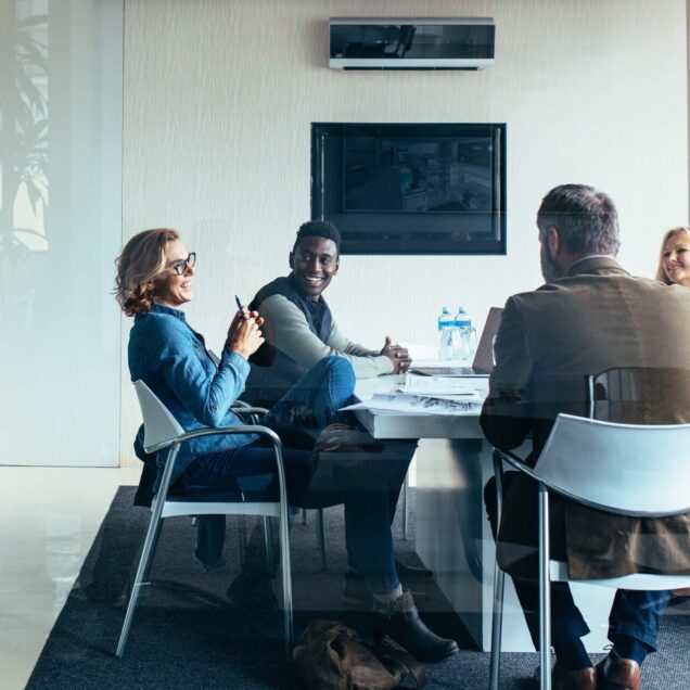 People sitting around a desk having a meeting.